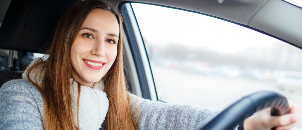 junge Frau sitzt hinter Lenkrad im Auto